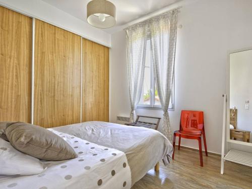 une chambre avec un lit et une chaise rouge dans l'établissement Charmant T2 à Arcachon, à 200m de la plage et proche du centre, avec parking et WIFI inclus - FR-1-433-125, à Arcachon
