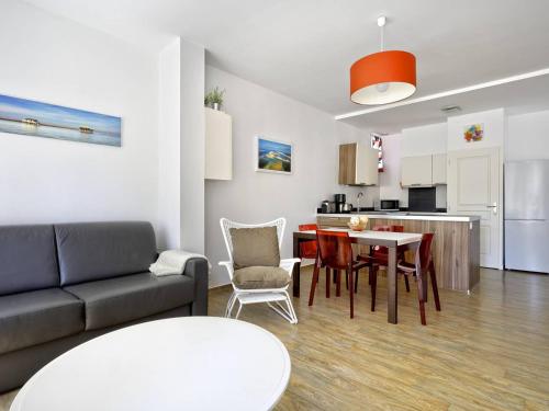 un salon avec un canapé et une table et une cuisine dans l'établissement Charmant T2 à Arcachon, à 200m de la plage et proche du centre, avec parking et WIFI inclus - FR-1-433-125, à Arcachon