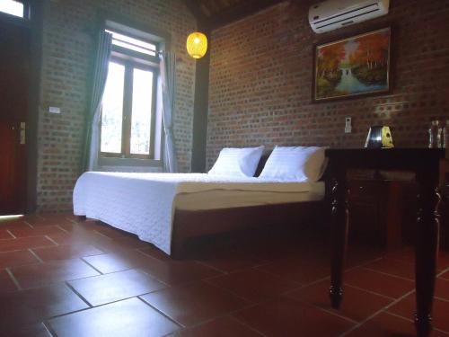 a bedroom with a bed and a brick wall at Ninh Binh Nature Homestay in Ninh Binh