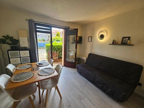 un salon avec une table et un canapé dans l'établissement Studio Cabine Charmant au Centre de Saint-Palais, Proche Plage, Terrasse et Parking Privé - FR-1-550-85, à Saint-Palais-sur-Mer