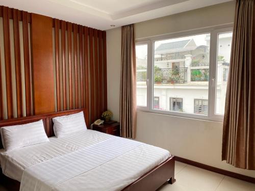 a bedroom with a bed and a large window at Song Lộc Hạ Long Hotel in Ha Long