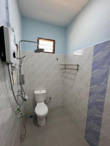 a bathroom with a toilet and a shower stall at Afdal homestay in Pantai Cenang
