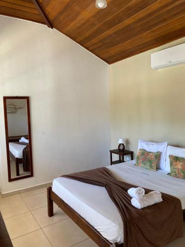 a bedroom with a large bed and a mirror at Hibiscus Center in Búzios