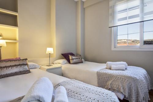 1 Schlafzimmer mit 2 Betten und einem Fenster in der Unterkunft Sarria Attic in Barcelona