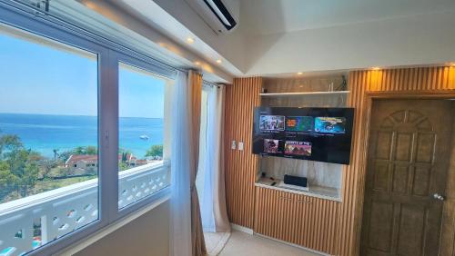 a room with a balcony with a view of the ocean at La Mirada Residences in Mactan