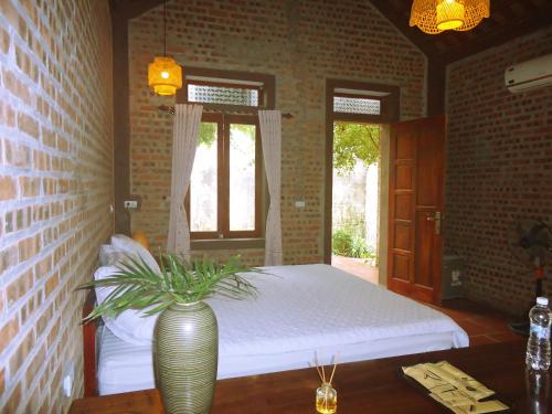 a bedroom with a bed and a vase on a table at Ninh Binh Nature Homestay in Ninh Binh