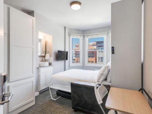 a bedroom with a bed and a desk and a window at The Dorel SF in San Francisco