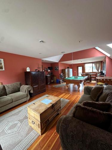 a living room with couches and a pool table at Paradise Acres Ranch in Nanoose Bay
