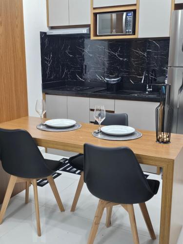a dining room table with two chairs and a microwave at Stúdio 81 Tatuapé Aconchegante in Sao Paulo