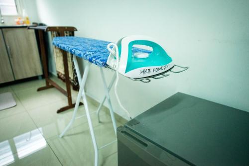 a room with a table with a iron on it at MKB Homestay - Landed Studio room with 2 Queen bed and Free gated Parking in Shah Alam