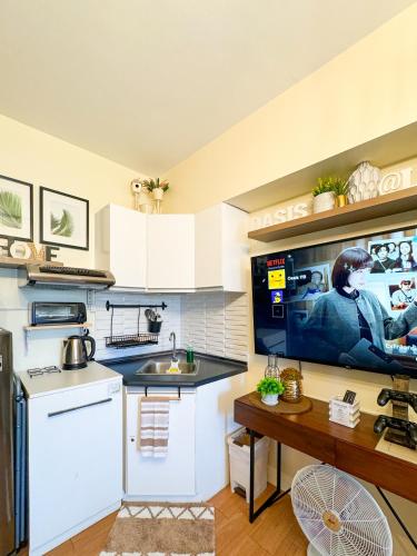 a kitchen with a sink and a tv on a wall at An Oasis in Tagaytay - Serin in Tagaytay