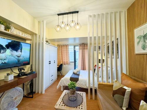 a bedroom with a bed and a tv in a room at An Oasis in Tagaytay - Serin in Tagaytay