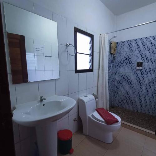 a white bathroom with a sink and a toilet at Khao Sok Holiday Resort in Khao Sok National Park