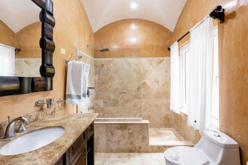 a bathroom with a sink and a toilet and a tub at Matapalo 203- 2 Bedroom Condo At Tamarindo in Tamarindo