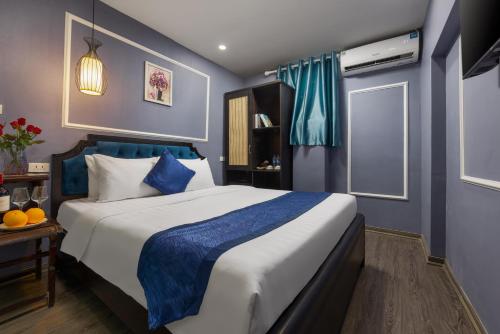 Un dormitorio con una cama grande con paredes azules. en Amanda Boutique Hotel & Travel, en Hanói