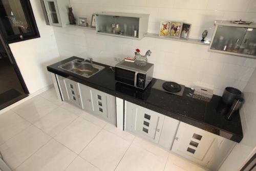 a kitchen with a black counter top and a microwave at Villa Bayu Lovina 2bedroom villa, private pool in Lovina