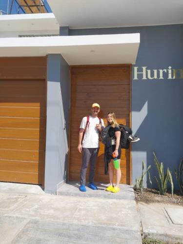 a man and a woman standing in front of a building at Hurin Hotel in Ica