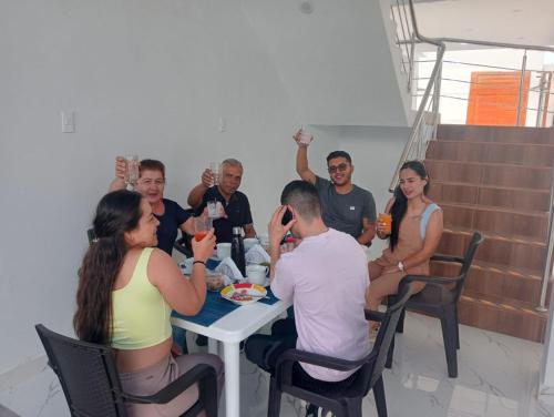 a group of people sitting around a table with drinks at Hurin Hotel in Ica