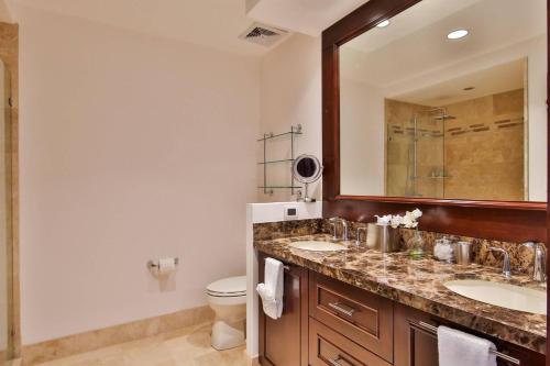 a bathroom with two sinks and a toilet and a mirror at 360 Splendor 305 Ocean View Condo- With Breakfast in Playa Flamingo