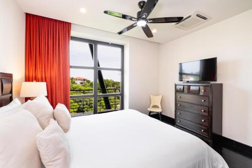 a bedroom with a white bed and a window at Condo La Perla 163, Ocean View 3 Bedroom Penthouse in Tamarindo