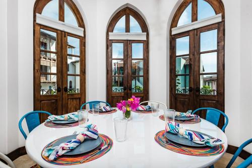a dining room with a white table and blue chairs at Plaza Carlota 2 At Las Catalinas in Playa Danta
