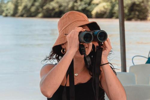 a woman in a hat taking a picture with a camera at Sunrise 6- Ocean View 2 Br Condo, Steps To The Beach in Tamarindo