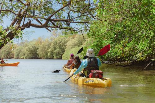 a group of people kayaking on a river at Sunrise 6- Ocean View 2 Br Condo, Steps To The Beach in Tamarindo
