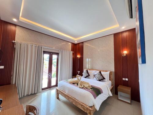une chambre avec un lit et une grande fenêtre dans l'établissement Lime Penida Cottages, à Nusa Penida