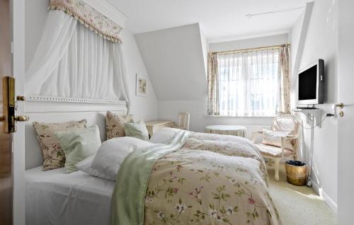 a white bedroom with a bed and a television at Cozy Home In Faaborg With Wifi in Fåborg