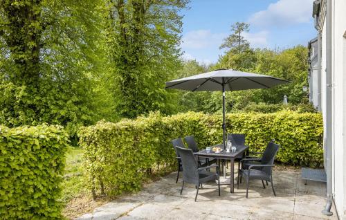 a table and chairs with an umbrella on a patio at Cozy Home In Faaborg With Wifi in Fåborg