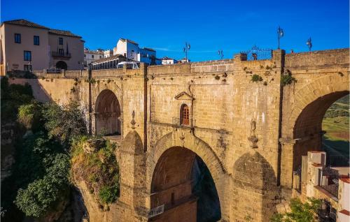 an old stone bridge over a river with buildings at Pet Friendly Home In Algatocin in Algatocín
