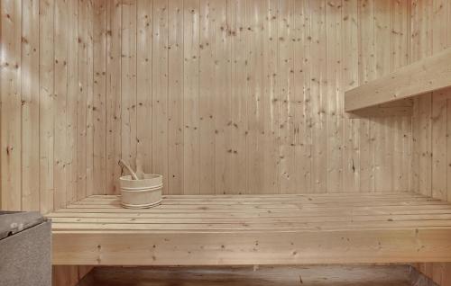 a wooden sauna with a bucket on a wooden platform at Holiday Home Snedsted 59 in Stenbjerg