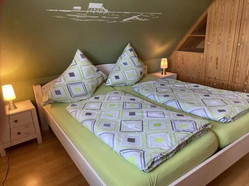 a bed with pillows on it in a bedroom at Alter Badweg Holiday Apartment 4 in Sankt Peter-Ording