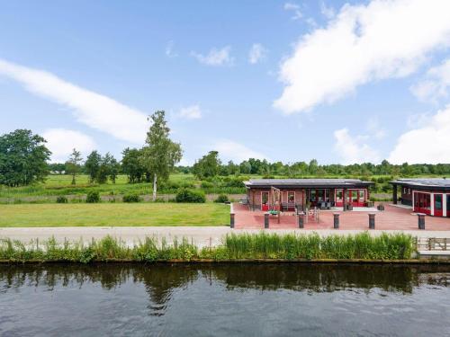a building next to a body of water at Holiday Home in Friesland near Canal & Lake in Schuilenburg