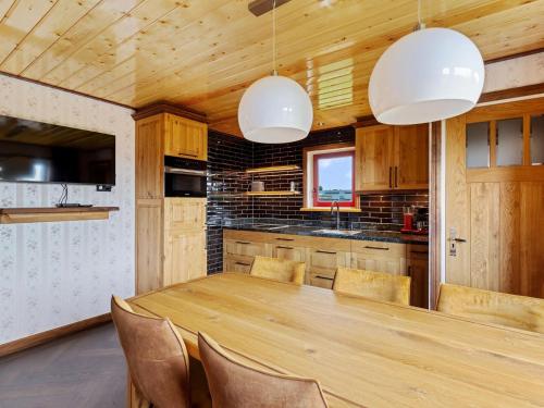 a kitchen with a wooden table and chairs at Holiday Home in Friesland near Canal & Lake in Schuilenburg