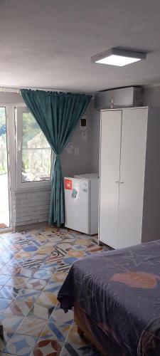 a bedroom with a bed and a window and a floor at Casutele verzi din Ocnele Mari in Ocnele Mari