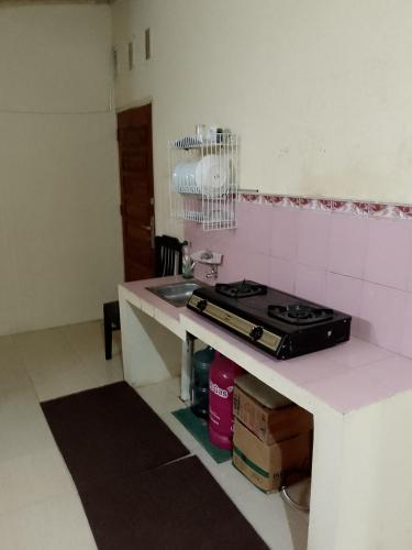 a kitchen with a stove and a counter top at Firza Maqita Homestay Syariah in Payakumbuh