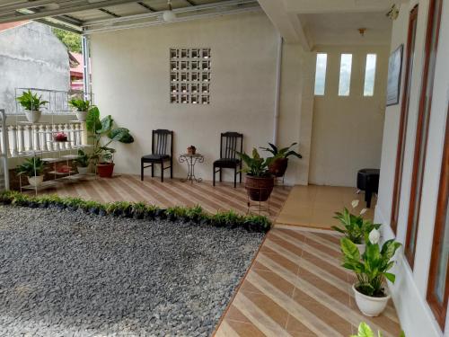 a living room with two chairs and plants at Firza Maqita Homestay Syariah in Payakumbuh