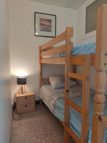 une chambre avec deux lits superposés et une lampe dans l'établissement Hespérides, à Fort-Mahon-Plage