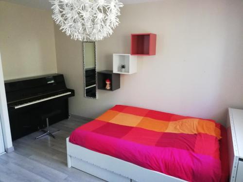 une chambre avec un lit coloré et un piano dans l'établissement Villa piscine chauffée,5ch ,climatisation, bar extérieur, à Lacanau