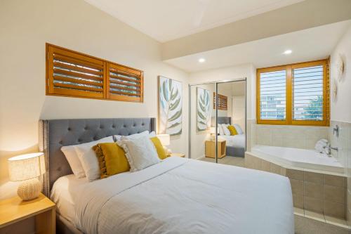 a bedroom with a large bed and a bath tub at Oceanfront Views at Rolling Surf Resort in Caloundra