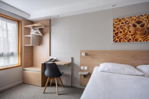 a bedroom with a bed and a desk and a chair at Brit Hotel Mulhouse Centre in Mulhouse