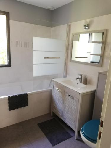 une salle de bain avec un lavabo, une baignoire et des toilettes dans l'établissement Villa piscine chauffée,5ch ,climatisation, bar extérieur, à Lacanau