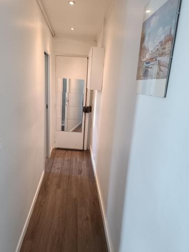 - un couloir avec une porte blanche et du parquet dans l'établissement Buttes Chaumont, à Paris