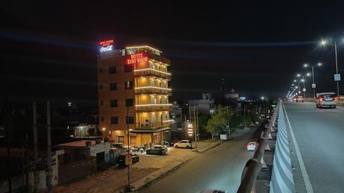 a building with a red sign on top of it at night at Hotel East Wood Amritsar in Amritsar