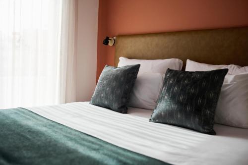 a bedroom with a bed with two pillows on it at Neve Eilat Hotel By Atlas Hotels in Eilat