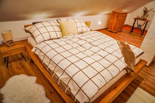 a bedroom with a large bed with a plaid blanket at Weinkeller Gehringer in Guntersdorf