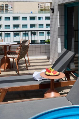 a plate of fruit on a table on a balcony at Neve Eilat Hotel By Atlas Hotels in Eilat