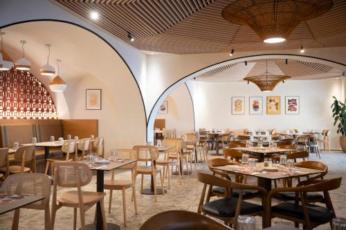 a restaurant with tables and chairs in a room at Neve Eilat Hotel By Atlas Hotels in Eilat