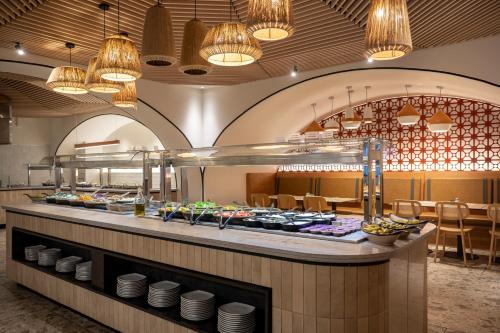 a buffet line in a restaurant with plates of food at Neve Eilat Hotel By Atlas Hotels in Eilat